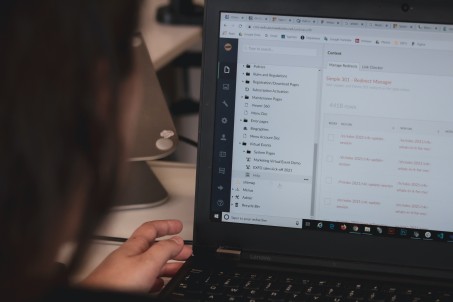 Die Kamera hat eine Person bei der Arbeit am Laptop festgehalten, sodass die Betrachter*in selbst den Blickwinkel dieser einnimmt. Die Arbeit auf dem Bildschirm hat Bezug zur Dokumentation, der Text ist allerdings auf Englisch.